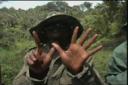 Konžský voják ukazuje na kameru na prstech počet žen které zneužil